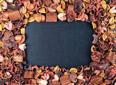 Frame of dried exotic flowers with a black chalk board in the middle.