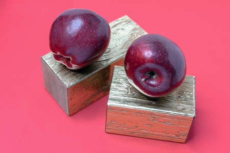 Red apples on gold coasters and a red background.の写真素材