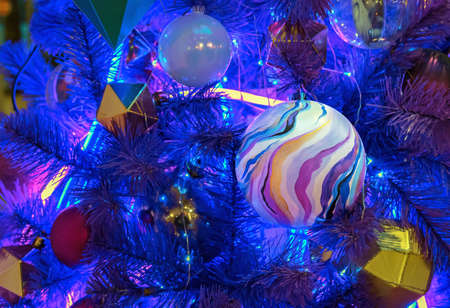Christmas ball in space style on a Christmas tree with blue neon backlights.の写真素材