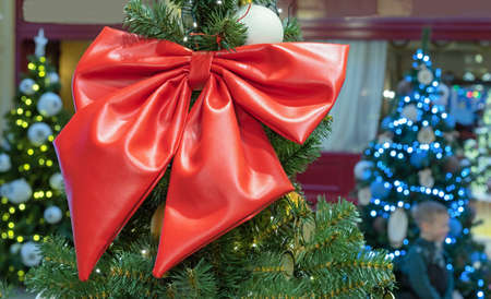 Large red bow from eco leather at the top of the Christmas tree.の写真素材