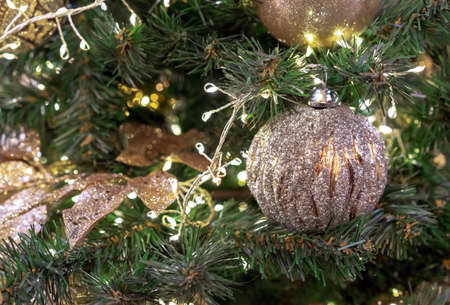 Gold-colored Christmas ball with silver plating on the Christmas tree.の写真素材