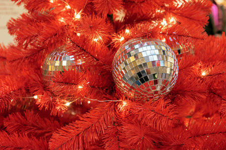 Christmas disco balls on a red Christmas tree.の写真素材