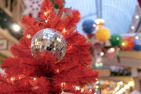 Christmas disco ball on top of the red Christmas tree.の写真素材