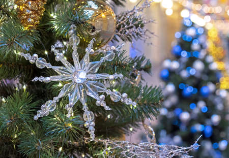 Glass snowflake and Christmas balls on a Christmas tree with a garland.の写真素材