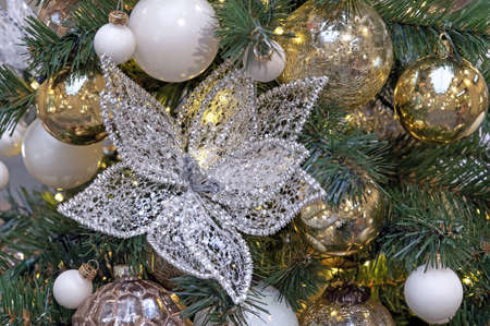 Glass poinsettia flower and yellow Christmas balls on the Christmas tree.の写真素材