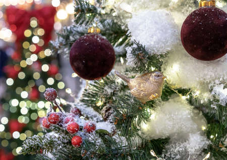 Christmas toy golden bird and burgundy Christmas balls on the background of the beautiful bokeh.の写真素材