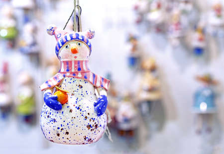 Snowman with a orange pot in a winter hat and scarf.の写真素材