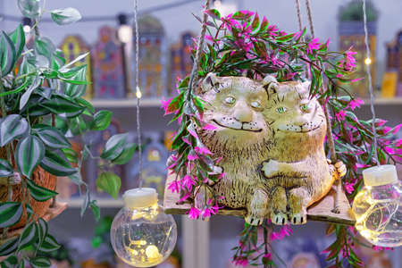 Ceramic figurines of cats in love hugging on a swing.の写真素材