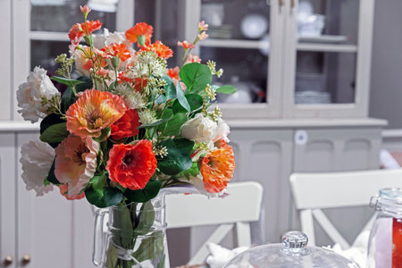 Floral arrangement with white and orange poppies in a modern kitchen interior.の写真素材