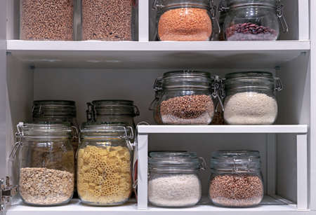 Glass jars with pasta, various cereals and grains. Food storage concept.の写真素材
