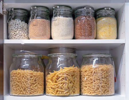 Glass jars with pasta, various cereals and grains. Food storage concept.の写真素材