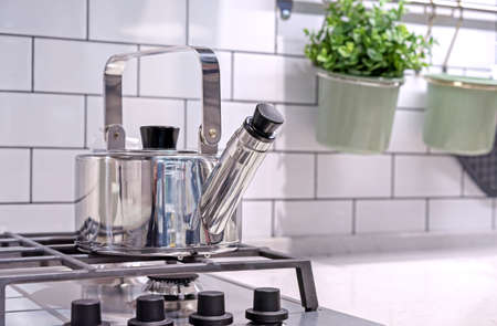 Metal kettle with a whistle on a kitchen gas stove.の写真素材