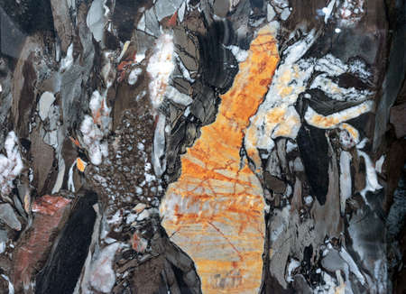 Texture of natural gray-black quartz stone with orange mineral inclusions.の写真素材