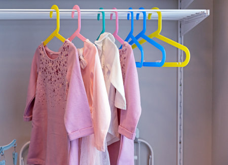 Children's dresses on colorful coat hangers. Children's clothing, children's stores.の写真素材
