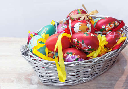 Wooden Easter eggs with floral ornaments in a wicker basket.の写真素材
