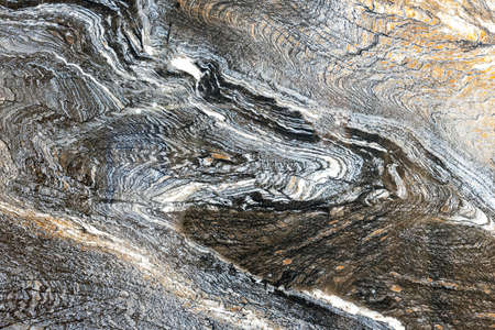 Texture of natural gray-black quartz stone with orange mineral inclusions.の写真素材
