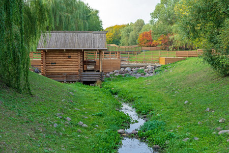 Wooden house near a small river against the backdrop of autumn nature.の写真素材