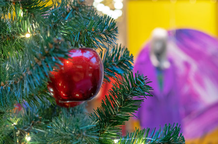 Red apple on the Christmas tree against the backdrop of a showcase with mannequins.の写真素材