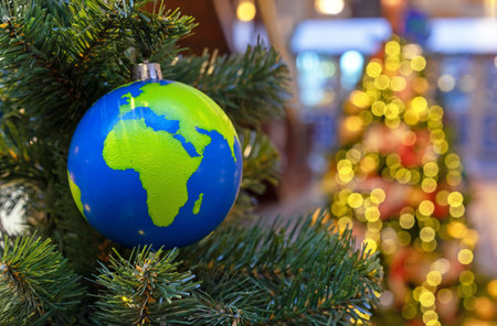 Globe-shaped Christmas ball with countries and continents on the Christmas tree.の写真素材
