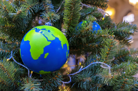 Globe-shaped Christmas ball with countries and continents on the Christmas tree.の写真素材