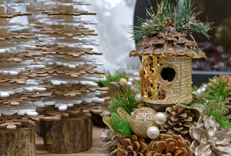 Birdhouse with gold sequins in a Christmas composition with cones and pearls.の写真素材