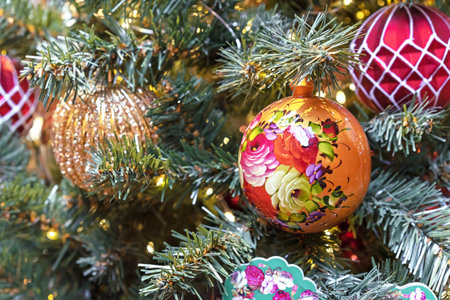 Christmas ball with floral ornament on Christmas tree with garland. Handmade Christmas decorations.の写真素材
