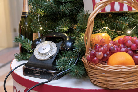Vintage black telephone and fruit basket near the Christmas tree.の写真素材
