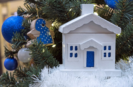 Snow-covered wooden house on Christmas tree. Christmas and New Year's decor.の写真素材