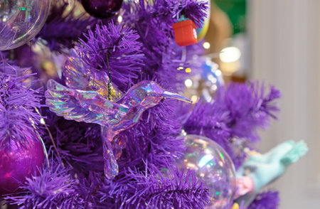 Glass christmas toy hummingbird on a violet Christmas tree.の写真素材