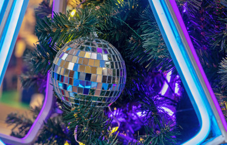 Disco Mirror Ball in neon light on a Christmas tree.の写真素材