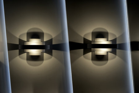 Two wall lights with symmetrical highlights on the wall.の写真素材