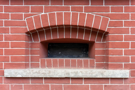 Decorative window in a building made of red decorative brick. Brick wall background.の写真素材