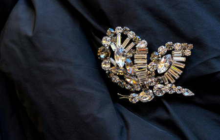 Butterfly-shaped brooch with large white rhinestones on black fabric.の写真素材