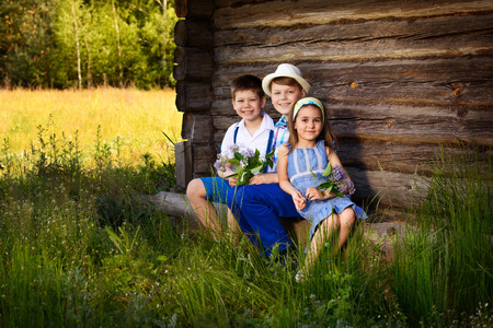 Portraits of friends, sitting near the wooden wall of the shedの写真素材