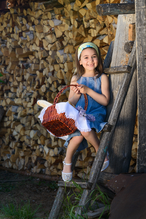 child smiling with no teeth sitting near the wooden wall of the shedの写真素材