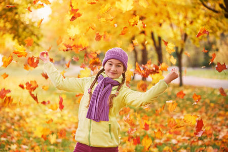 teen girl playing in autumn leaves.teenage girl to spend time with autumn leaves.の写真素材