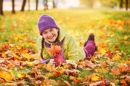 smiling teenage girl relaxing in autumn Park yellow.yellow.autumn portrait of baby in maple leafの写真素材