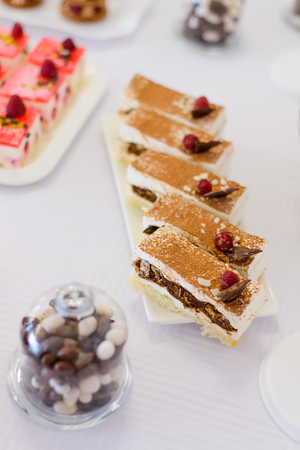 sweet desserts, cakes with berries and fruits served on the table. Beautifully laid out cakes on the saucer top view,soft focus.の写真素材