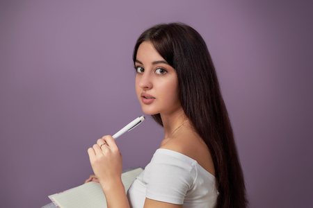 portrait of beautiful young woman with pen.portrait of a beautiful young woman studentの写真素材