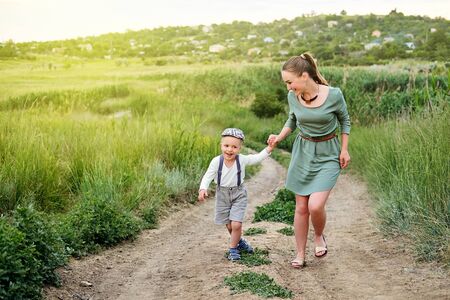 Mother and little son happy family. Attractive mom,kid boy are walking carefree outdoors summer.の写真素材