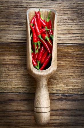 Red chili pepper in wooden scoopの写真素材
