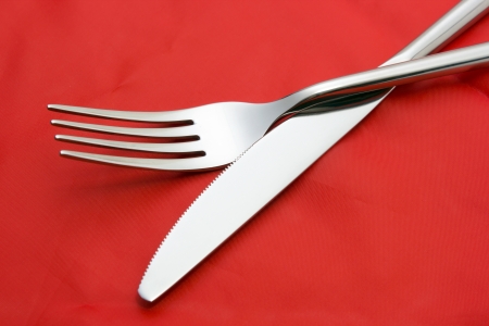 Fork and knife on red tableclothの写真素材