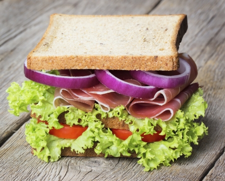Parma ham sandwich with vegetables on wooden tableの写真素材