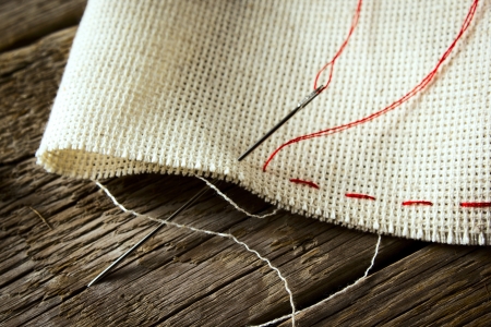 Needle and natural linen canvas texture for the background on wooden table の写真素材