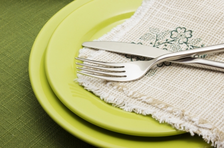 Green plates with fork and knifeの写真素材