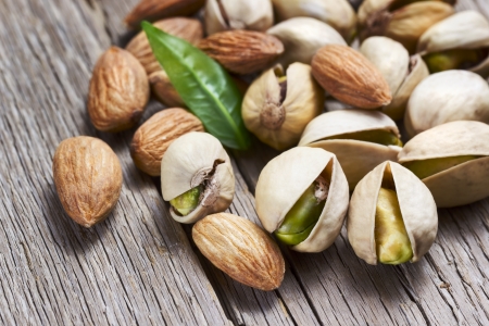 Almonds and pistachio with leaf on wooden backgroundの写真素材