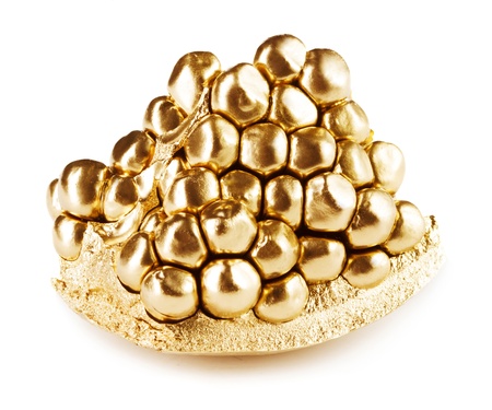 Piece of pomegranate in gold isolated on whiteの写真素材