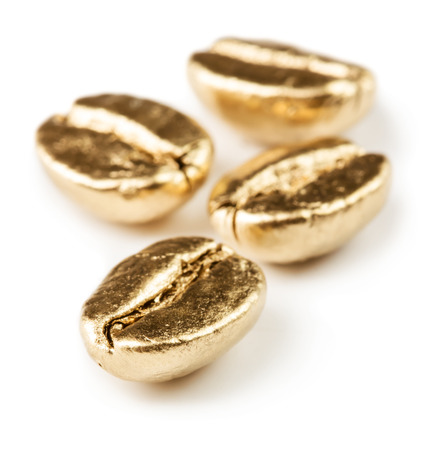 Gold coffee beans isolated on white の写真素材