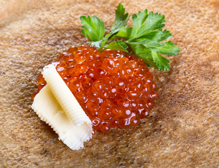 Pancakes with red caviar, parsley and butterの写真素材