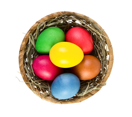 Easter eggs in nest basket isolated on white background. Top viewの写真素材